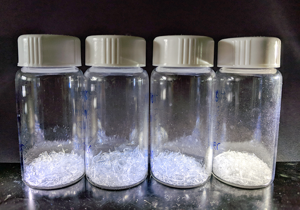 Four vials of synthesised nanoparticles which appear as small clear crystalites